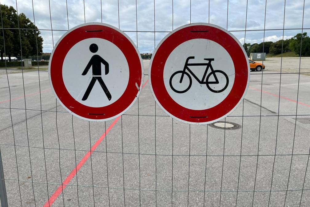 Verbotsschilder für Fußgänger und Fahrradfahrer am Baustellenzaun.