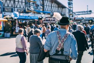 Älterer Wiesnbesucher in bayrischer Tracht auf der Wirtsbudenstraße