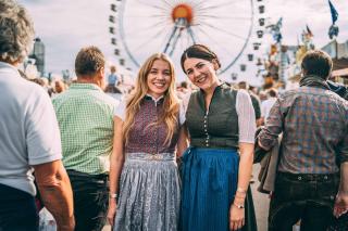 Zwei Besucherinnen in Tracht vor dem Riesenrad im Hintergrund Zwei Besucherinnen in Tracht vor dem Riesenrad im Hintergrund