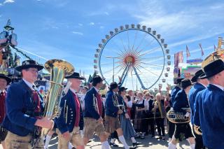 Blick durch den Trachtenzug auf das Riesenrad