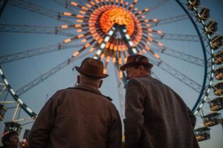 Zwei Männer vor dem Riesenrad auf dem Oktoberfest