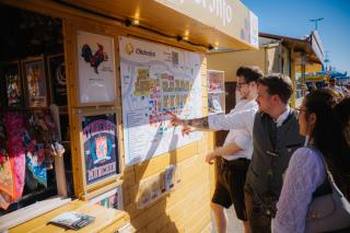Gäste an einem offiziellen Informationsstand auf dem Oktoberfest