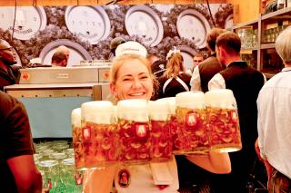 Bedienung bringt frisch gefüllte Maßkrüge auf dem Oktoberfest 
