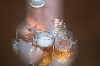 Menschen stoßen mit Maßkrügen an 